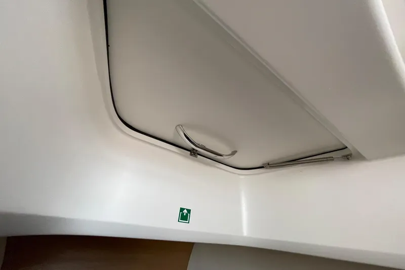 Slide: The Image of Ceiling hatch inside 2023 Nimbus Tender 8 boat with emergency exit sign. - 35