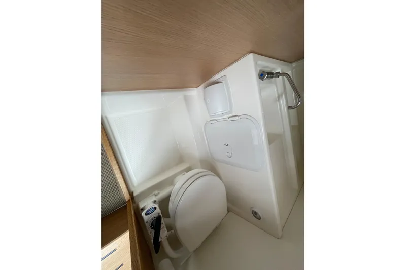 Slide: The Image of 2023 Nimbus Tender 8 boat interior bathroom with compact toilet and sink. - 38