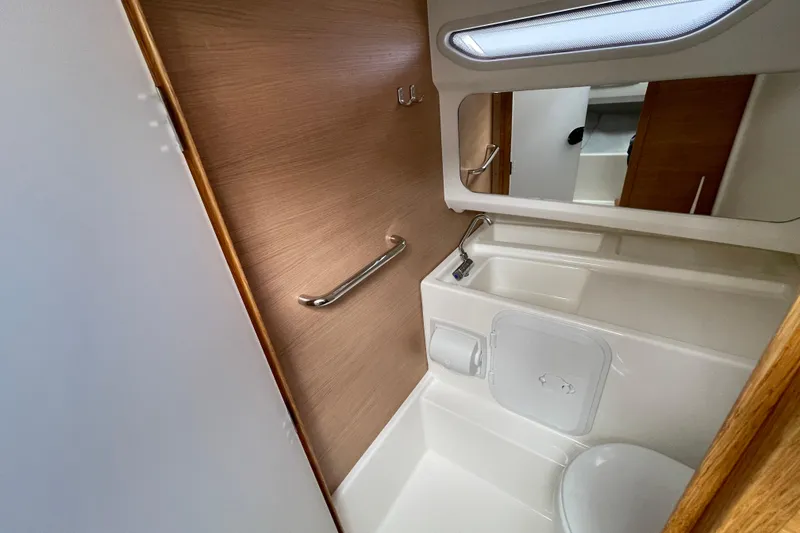 Slide: The Image of 2023 Nimbus Tender 8 boat bathroom with modern fixtures and wooden accents. - 40