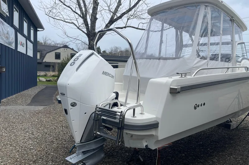 Slide: The Image of 2023 Nimbus Tender 8 boat with Mercury engine, parked outdoors. - 6