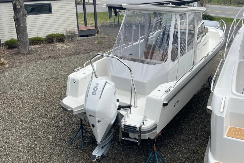 Slide: The Image of 2023 Nimbus Tender 8 boat with 300 HP outboard motor, parked on gravel. - 8