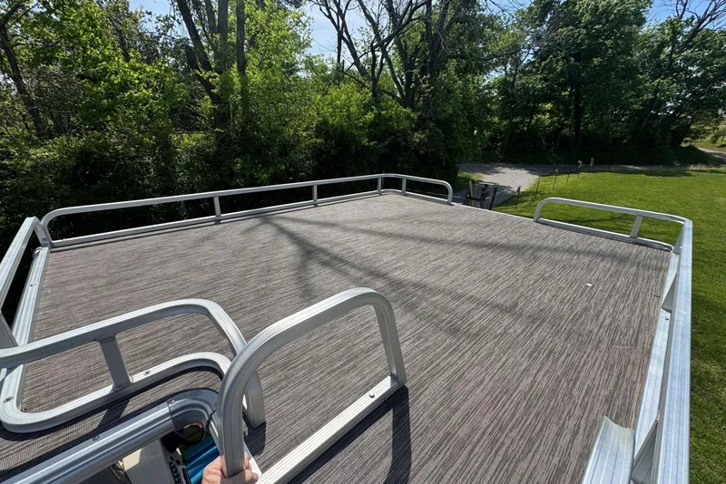 Slide: The Image of 2008 Voyager Pontoons 25 Extreme Cruise Express deck with railing, surrounded by lush greenery. - 16