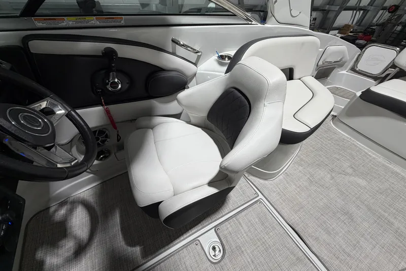 Slide: The Image of 2023 Crownline 280 SS boat interior with sleek white seating and modern steering wheel. - 12