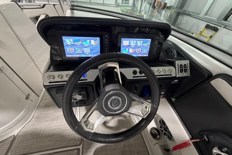 Slide: The Image of 2023 Crownline 280 SS boat dashboard with dual Garmin displays and steering wheel. - 20