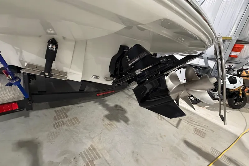Slide: The Image of 2023 Crownline 280 SS boat stern with propeller and outdrive in a garage. - 23