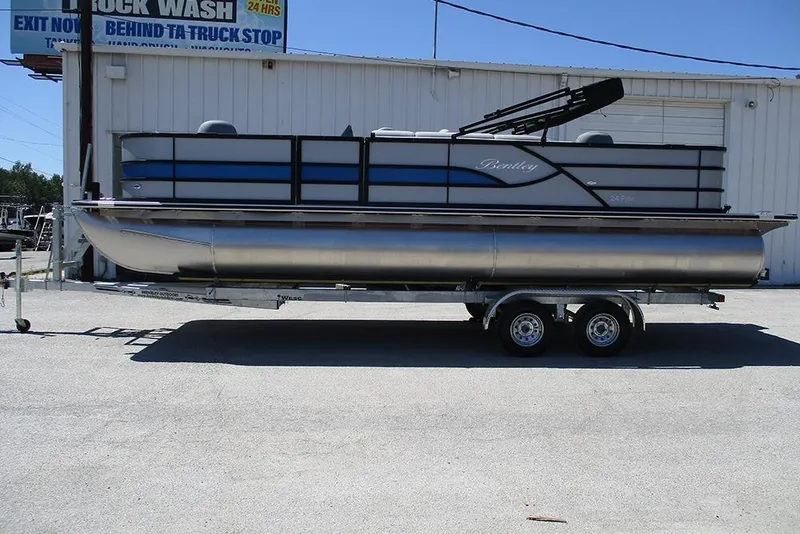 The Image of 2026 Bentley Pontoons Fish 243 4-Point on trailer outside a building. - 1