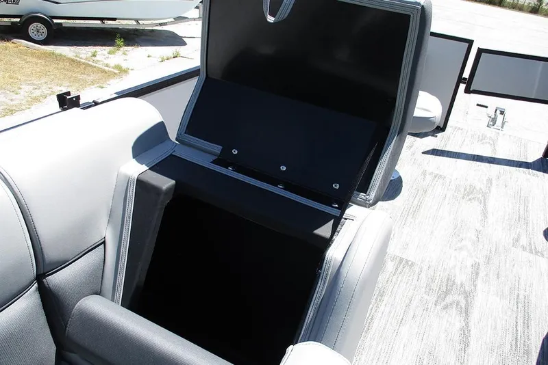 Slide: The Image of 2026 Bentley Pontoons Fish 243 4-Point, open storage compartment, gray seating, outdoor setting. - 20