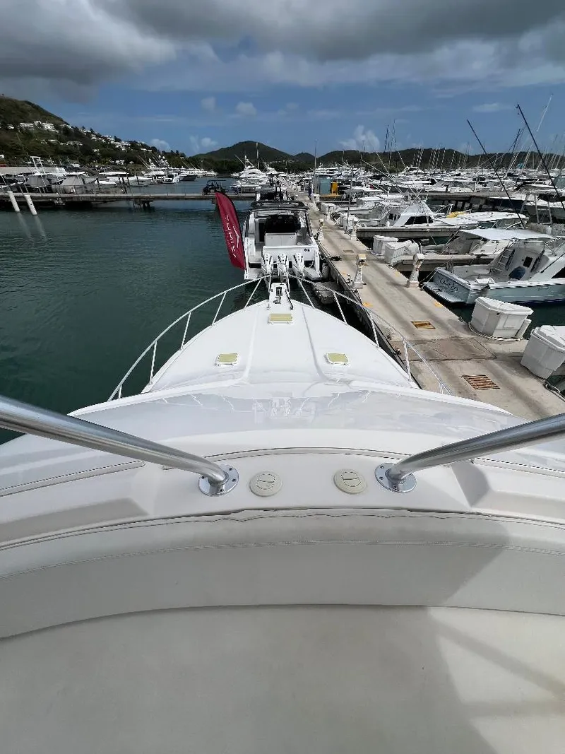 Slide: The Image of 2009 Bertram Convertible yacht docked in a marina with scenic mountain backdrop. - 7