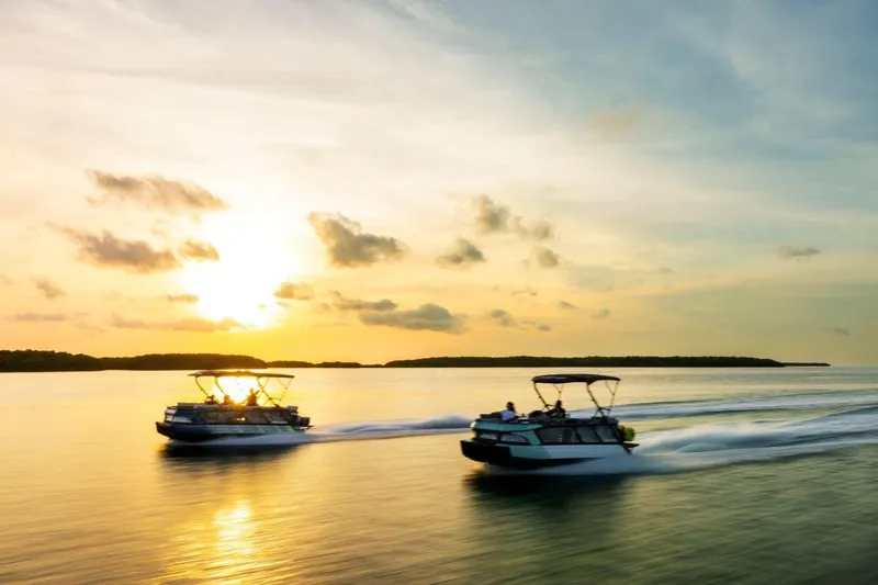 Slide: The Image of 2026 Sea-Doo Switch Cruise Limited 18 boats cruising at sunset on calm water. - 7