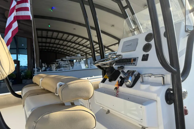 Slide: The Image of 2016 Key West 239 FS boat interior with steering console and American flag. - 12