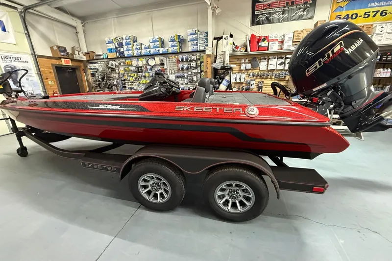 Slide: The Image of 2026 Skeeter ZX150 boat in showroom, red color, Yamaha engine, on trailer. - 3