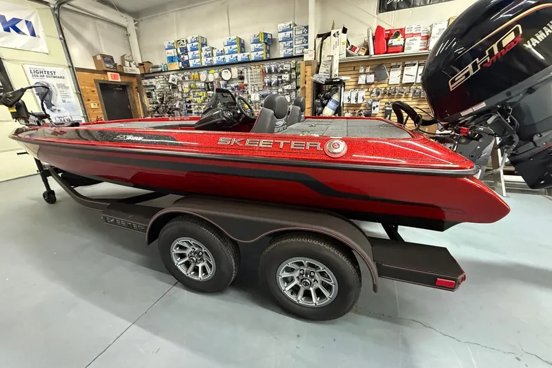 Slide: The Image of 2026 Skeeter ZX150 boat in showroom, red finish, on trailer, Yamaha outboard motor. - 5