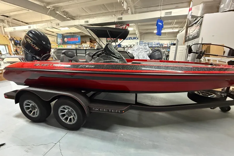 Slide: The Image of 2026 Skeeter ZX150 boat in showroom, red and black design, on trailer. - 6