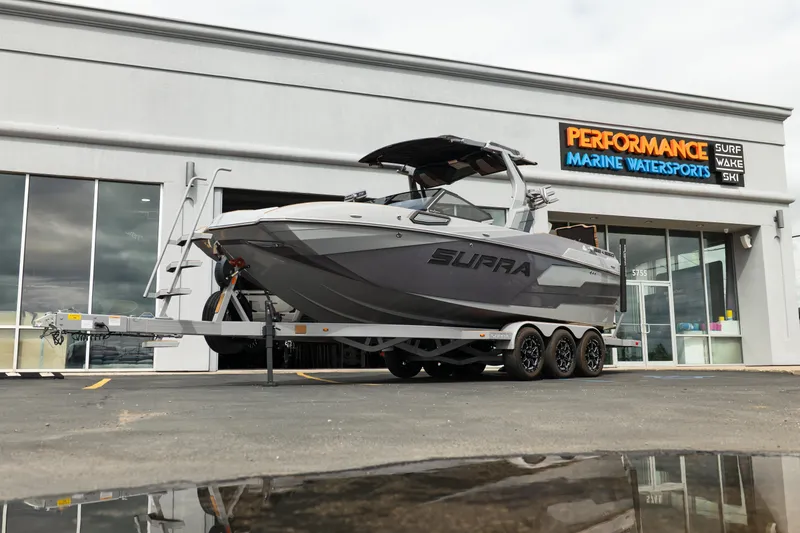 The Image of 2025 Supra SE 550 boat on trailer outside Performance Marine Watersports store. - 1