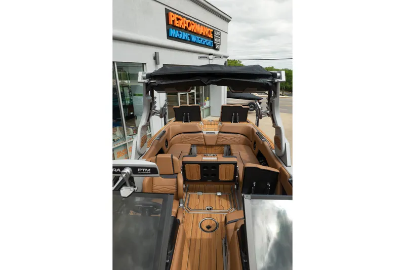 Slide: The Image of 2025 Supra SE 550 boat interior with luxurious tan seating and sleek design at a marine dealership. - 39