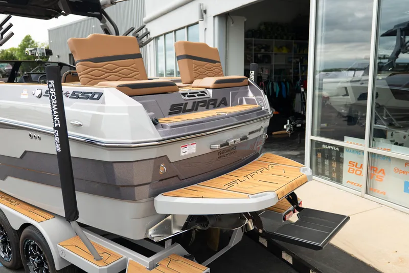 Slide: The Image of 2025 Supra SE 550 boat with tan seats and teak swim platform. - 5