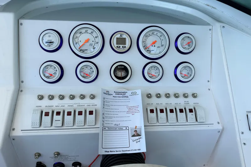 Slide: The Image of Dashboard of a 2004 Envision 3200 Intruder boat with gauges and checklist. - 12