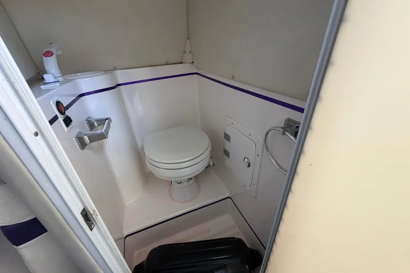 Slide: The Image of Compact bathroom inside a 2004 Envision 3200 Intruder boat, featuring a toilet and shower. - 17