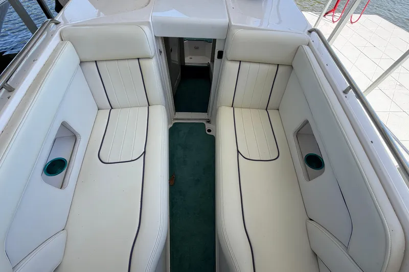 Slide: The Image of Interior of a 2004 Envision 3200 Intruder boat with white seating and teal carpet. - 23