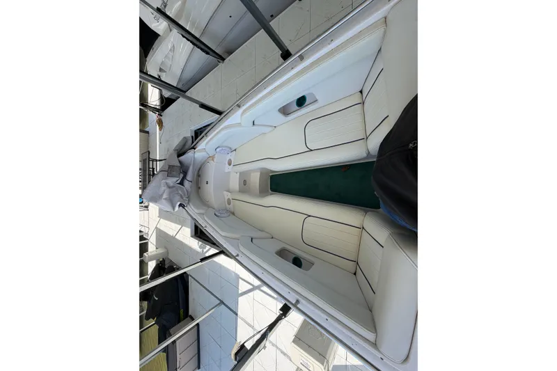 Slide: The Image of 2004 Envision 3200 Intruder boat interior with white seating and green carpet. - 24