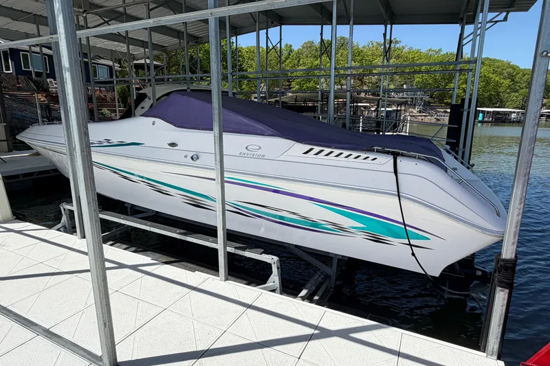 Slide: The Image of 2004 Envision 3200 Intruder boat docked, featuring sleek design and vibrant graphics. - 3