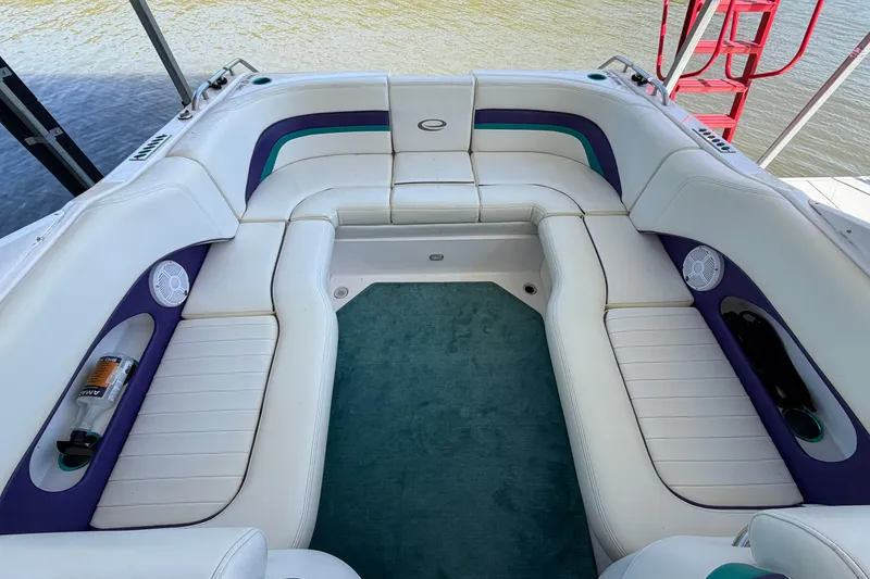 Slide: The Image of Interior of a 2004 Envision 3200 Intruder boat with white seating and teal accents. - 5