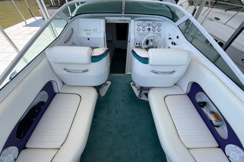 Slide: The Image of 2004 Envision 3200 Intruder boat interior with white seating and teal carpet. - 7