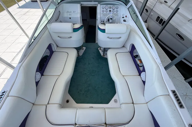 Slide: The Image of 2004 Envision 3200 Intruder boat interior with white seating and green carpet. - 8