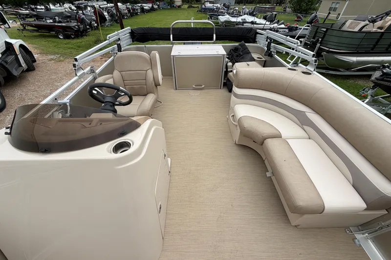 Slide: The Image of 2013 Cypress Cay Cabana 240 pontoon boat interior with beige seating and steering console. - 3