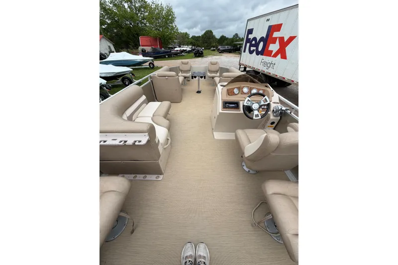 Slide: The Image of 2013 Cypress Cay Cabana 240 pontoon boat interior with beige seating and steering console. - 5