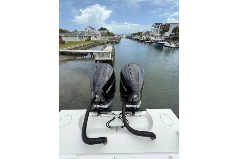 Slide: The Image of 2024 Contender 28 Tournament boat with dual Mercury outboard engines in a scenic marina. - 5