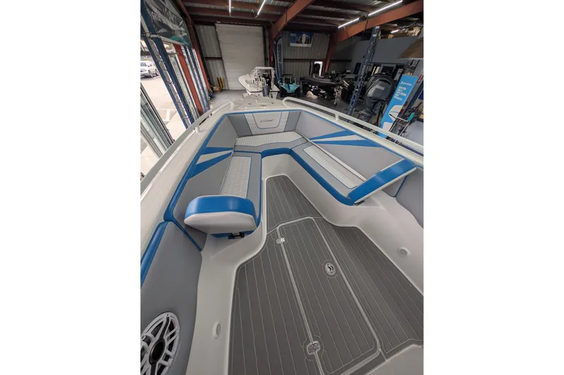 Slide: The Image of 2024 Concept 27' CC boat interior with blue and gray seating in a showroom. - 2