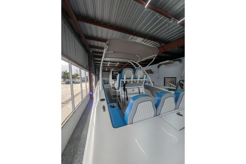 Slide: The Image of 2024 Concept 27' CC boat interior with blue and white seating, under a metal roof. - 5