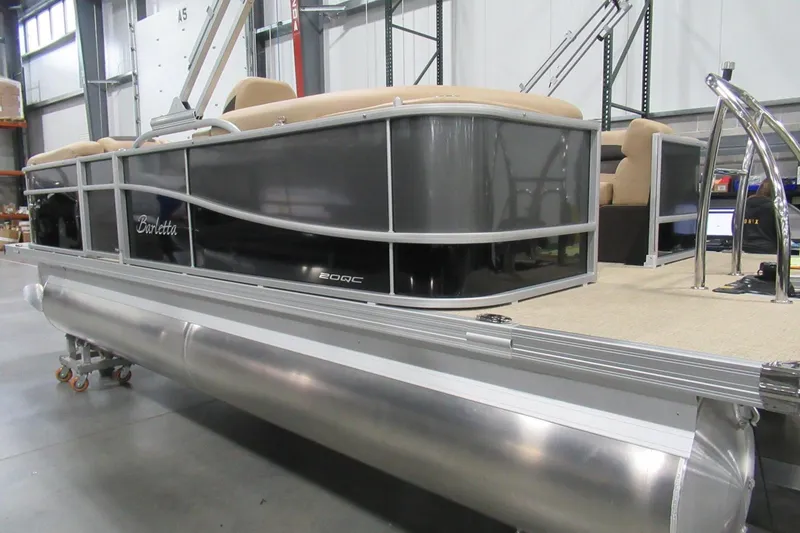The Image of 2022 Barletta C20QC pontoon boat in warehouse, featuring sleek design and beige seating. - 1