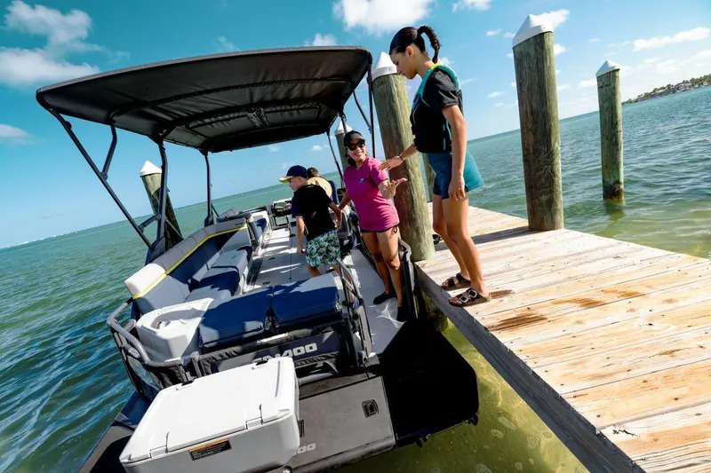 Slide: The Image of 2026 Sea-Doo Switch Cruise 18 docked with people boarding under sunny skies. - 6