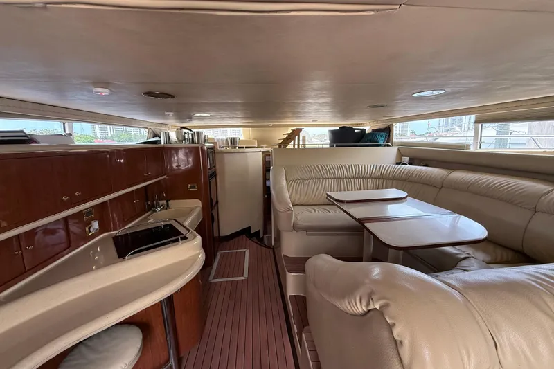 Slide: The Image of Luxurious interior of 2001 Sea Ray 450 Express Bridge yacht with leather seating and wooden cabinetry. - 13