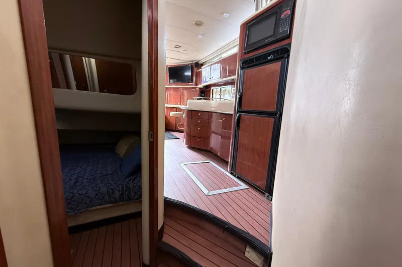Slide: The Image of Interior of 2001 Sea Ray 450 Express Bridge yacht with wood finishes and cozy cabin. - 16