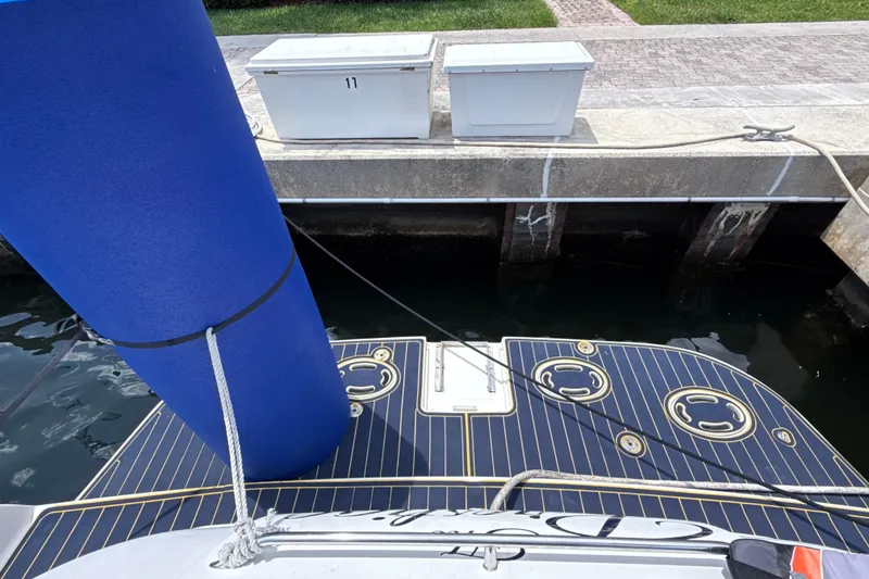 Slide: The Image of 2001 Sea Ray 450 Express Bridge docked, featuring a blue fender and striped deck. - 2