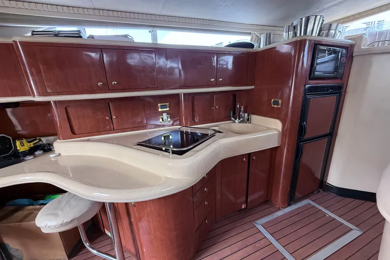 Slide: The Image of Luxurious 2001 Sea Ray 450 Express Bridge yacht kitchen with wood cabinetry and modern appliances. - 23