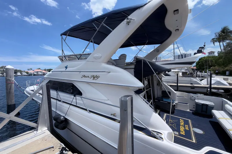 Slide: The Image of 2001 Sea Ray 450 Express Bridge yacht docked at marina under clear blue sky. - 25