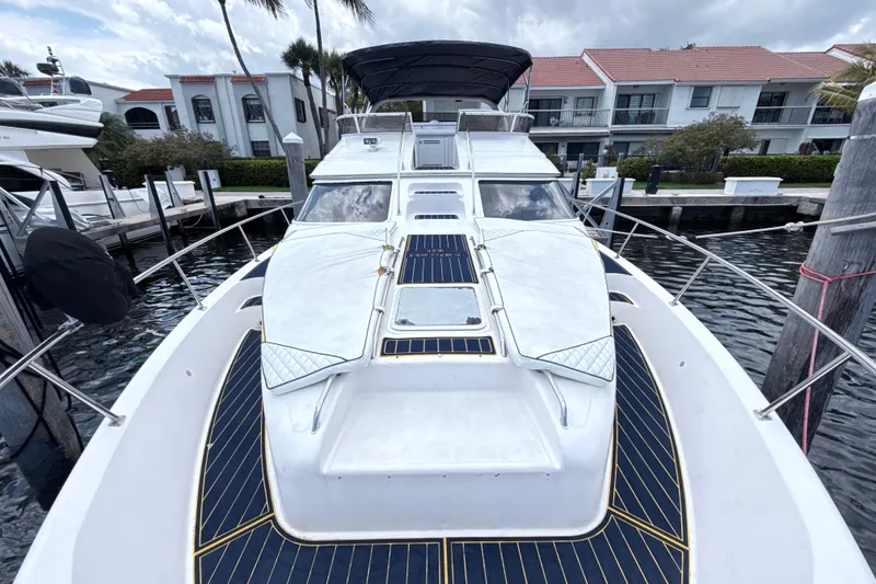 Slide: The Image of 2001 Sea Ray 450 Express Bridge yacht docked at marina, showcasing sleek design and spacious deck. - 6