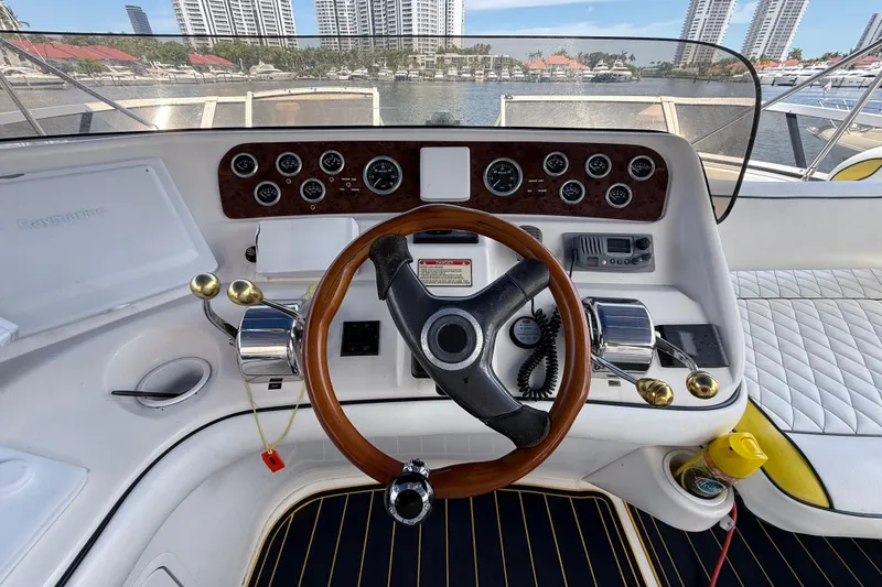 Slide: The Image of 2001 Sea Ray 450 Express Bridge helm with steering wheel, gauges, and controls. - 8