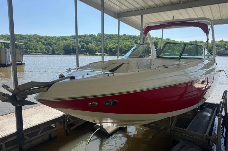 Slide: The Image of 2006 Rinker 282 Captiva Bowrider in dock, red and white design, under canopy. - 2