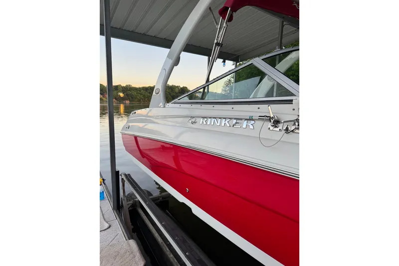 Slide: The Image of 2006 Rinker 282 Captiva Bowrider boat docked, featuring red and white exterior. - 27