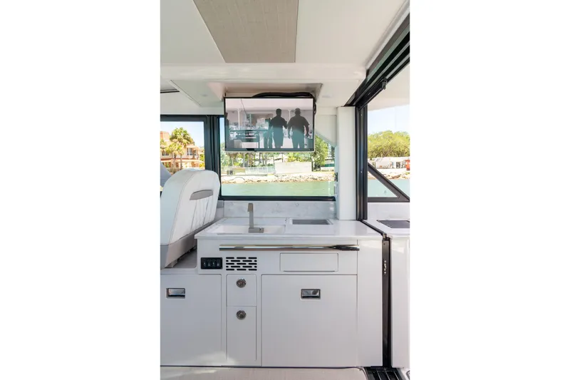Slide: The Image of Interior of 2026 Regal 36 XO yacht with modern kitchen and TV display. - 11