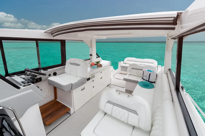 Slide: The Image of Luxurious 2026 Regal 36 XO yacht interior with plush seating, overlooking turquoise ocean waters. - 20