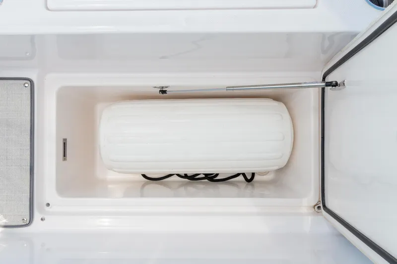 Slide: The Image of Storage compartment on 2026 Regal 36 XO boat, featuring a white fender and black rope. - 6