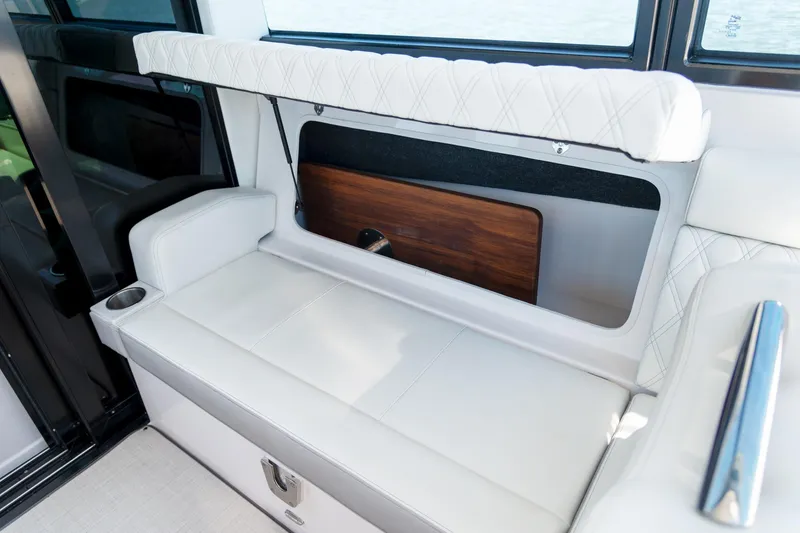 Slide: The Image of Luxurious seating area on 2026 Regal 36 XO boat with white upholstery and storage compartment. - 8