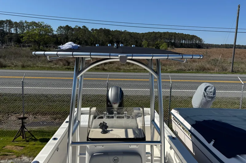 Slide: The Image of 2024 May-Craft 1900CC boat with T-top, parked near a road and fence. - 15