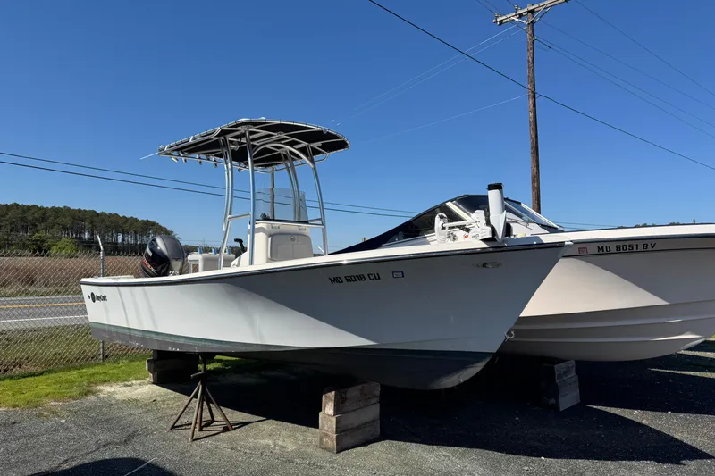 Slide: The Image of 2024 May-Craft 1900CC boat on display, elevated on blocks, with clear blue sky background. - 2